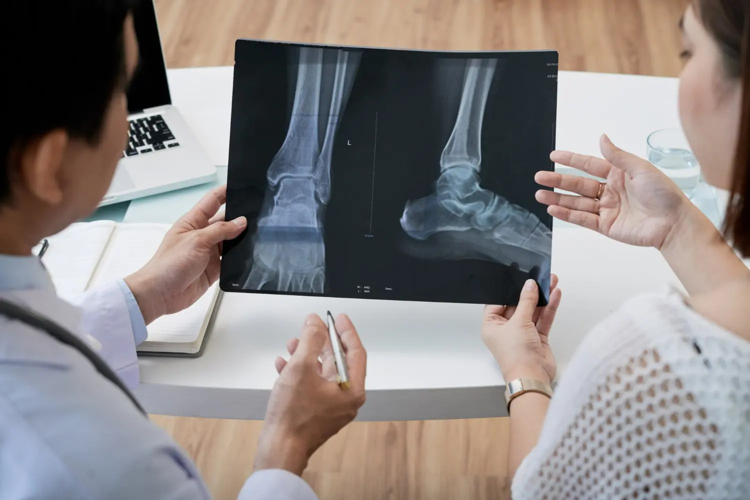 medico mostra lastra con fratture a donna