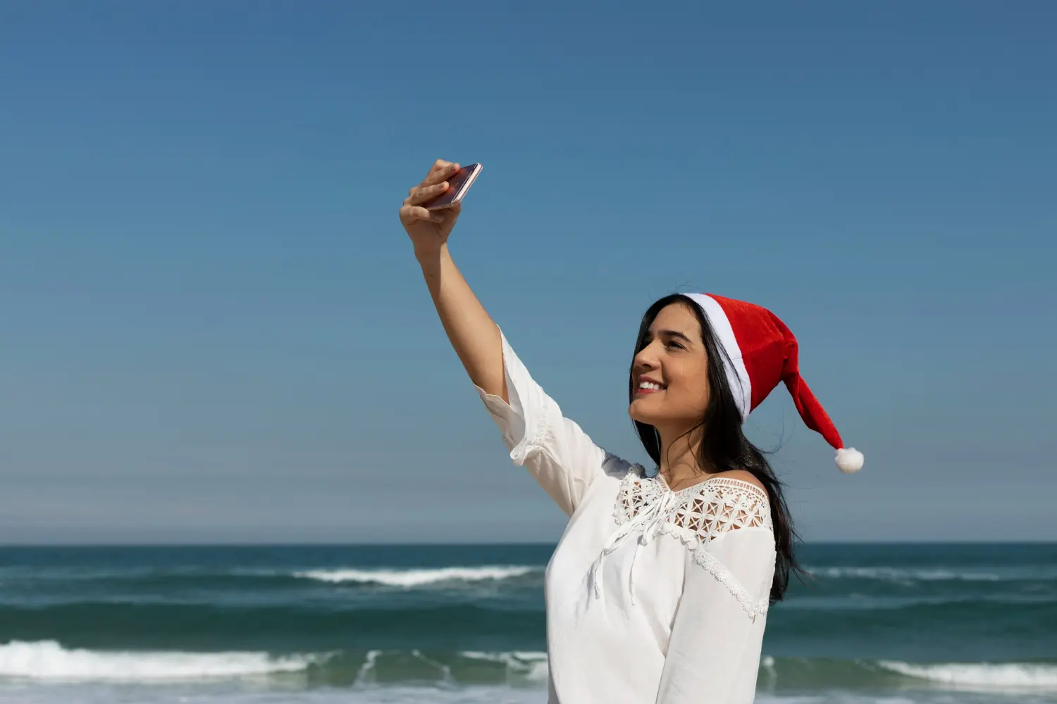 ragazza a natale fa selfie sul mare
