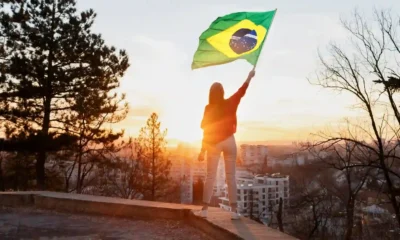 ragazza sventola bandiera del brasile al tramonto