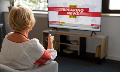 una signora seduta guarda la tv