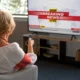 una signora seduta guarda la tv