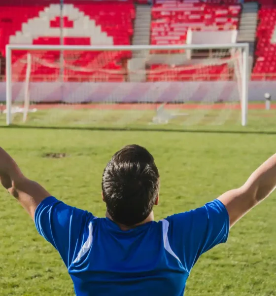 calciatore braccia aperte stadio