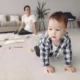 Bebé en el suelo explorando mientras se plantea quando iniziano a gattonare i bambini.
