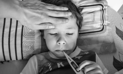 Niño con mal d’auto bambini vacanze en el asiento trasero del coche durante un viaje familiar.