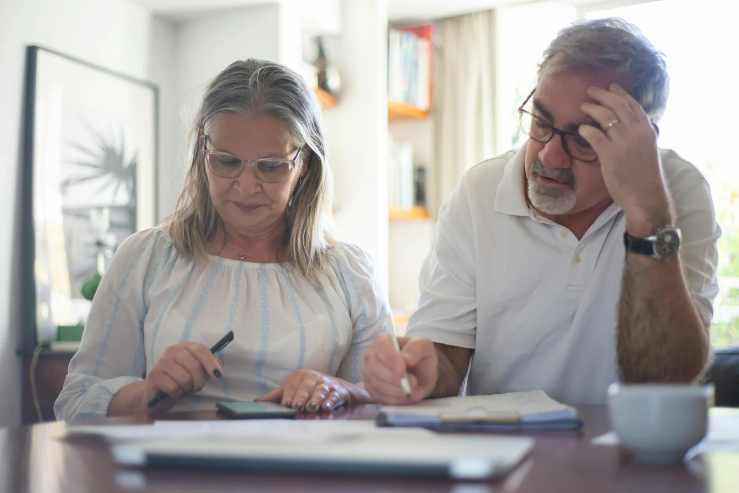 Foto de una pareja de personas mayores revisando facturas, útil para ilustrar quanto aumenta bolletta clienti vulnerabili