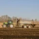 Foto de un agricultor esparciendo producto en el campo para ilustrar zeolite a cosa serve in agricoltura.
