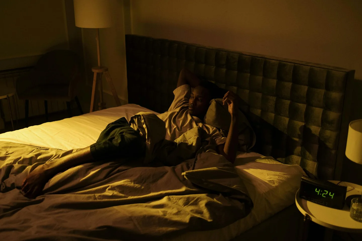 Hombre despierto en la cama de noche, ilustrando "perché svegliarsi alle tre di notte" y el problema de los despertares nocturnos.