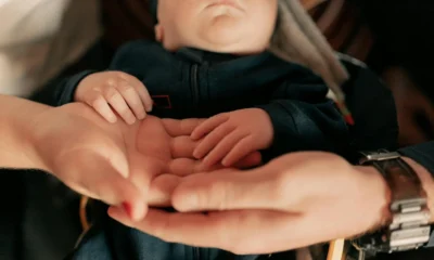 Manos de una familia con un recién nacido para ilustrar bonus nuovi nati ISEE