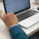 Persona trabajando en un ordenador con una hoja de cálculo para explicar come andare a capo su excel