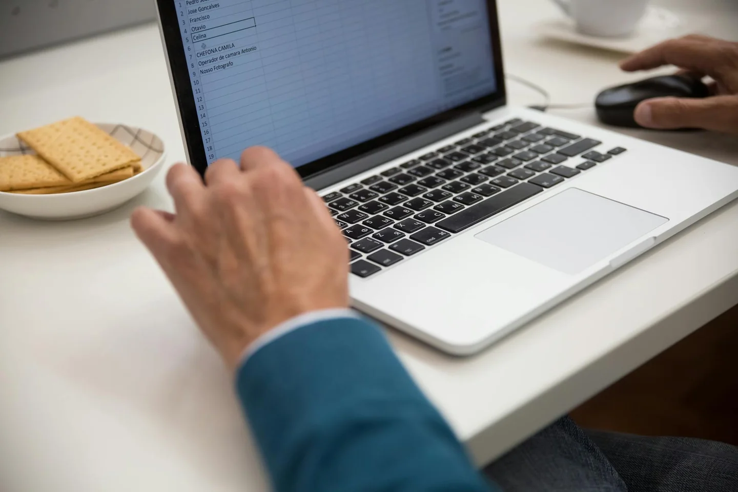 Persona trabajando en un ordenador con una hoja de cálculo para explicar come andare a capo su excel