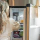 Frigorífico abierto en la cocina para ilustrar cómo ajustar la temperatura frigo spendere meno y ahorrar energía.