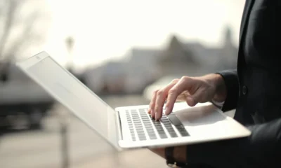 Persona usando un portátil sobre una mesa, ilustrando un artículo sobre browser con intelligenza artificiale.