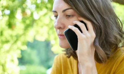 Persona recibiendo una truffa voce clonata durante una llamada telefónica sospechosa