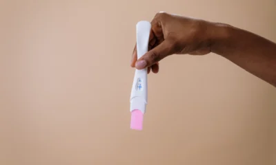 Mujer sosteniendo una prueba de embarazo para ilustrar cosa si sente quando l'ovulo viene fecondato