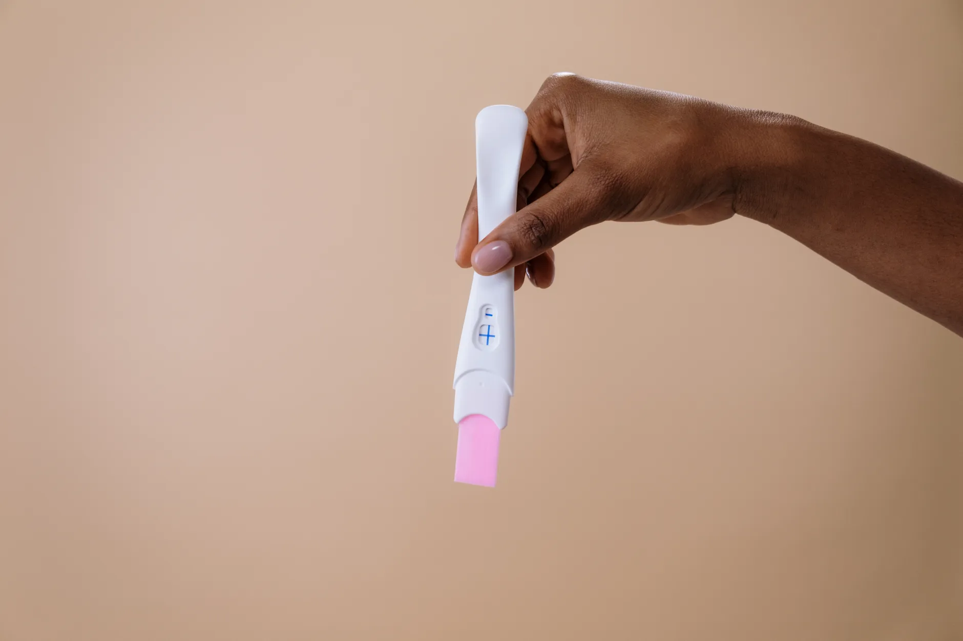 Mujer sosteniendo una prueba de embarazo para ilustrar cosa si sente quando l'ovulo viene fecondato