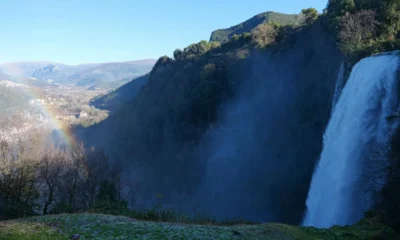 Imagen de un arcoíris sobre una cascada para ilustrar "quali sono i colori dell'arcobaleno" en un artículo sobre cómo se forma y qué colores presenta.