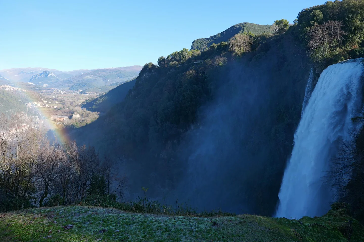 Imagen de un arcoíris sobre una cascada para ilustrar "quali sono i colori dell'arcobaleno" en un artículo sobre cómo se forma y qué colores presenta.