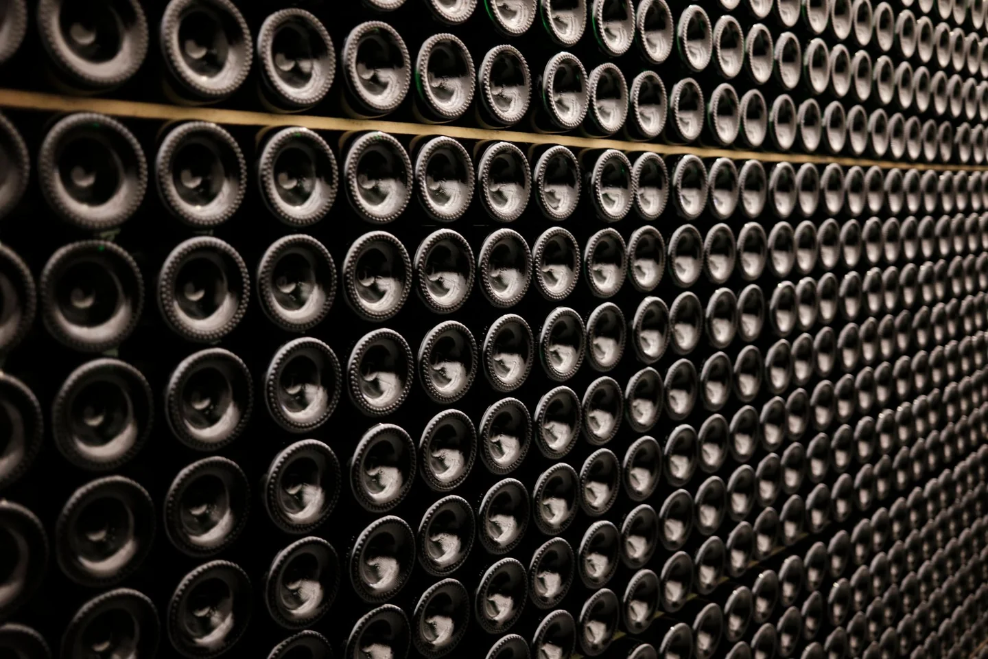 Botellas de vino en una bodega para ilustrar quando imbottigliare il vino per renderlo frizzante