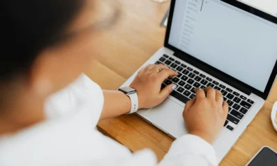 Mujer escribiendo un correo sobre intelligenza artificiale email en un ordenador portátil