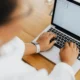 Mujer escribiendo un correo sobre intelligenza artificiale email en un ordenador portátil