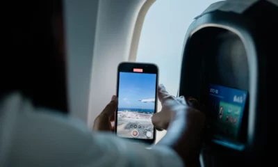 Pasajero usando el móvil en la cabina para ilustrar si può usare il telefono durante un volo.