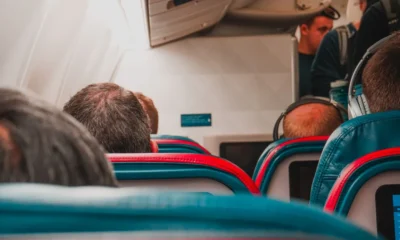 Pasajeros usando el Wi-Fi en a bordo de un avión, relacionado con si può usare il Wi-Fi in aereo.