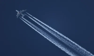 Fotografía de un avión dejando una estela blanca en el cielo, ideal para ilustrar perché gli aerei lasciano scie bianche nel cielo.