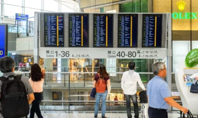 Foto de una persona usando una báscula de aeropuerto para comprobar quanto può pesare il bagaglio a mano antes de volar