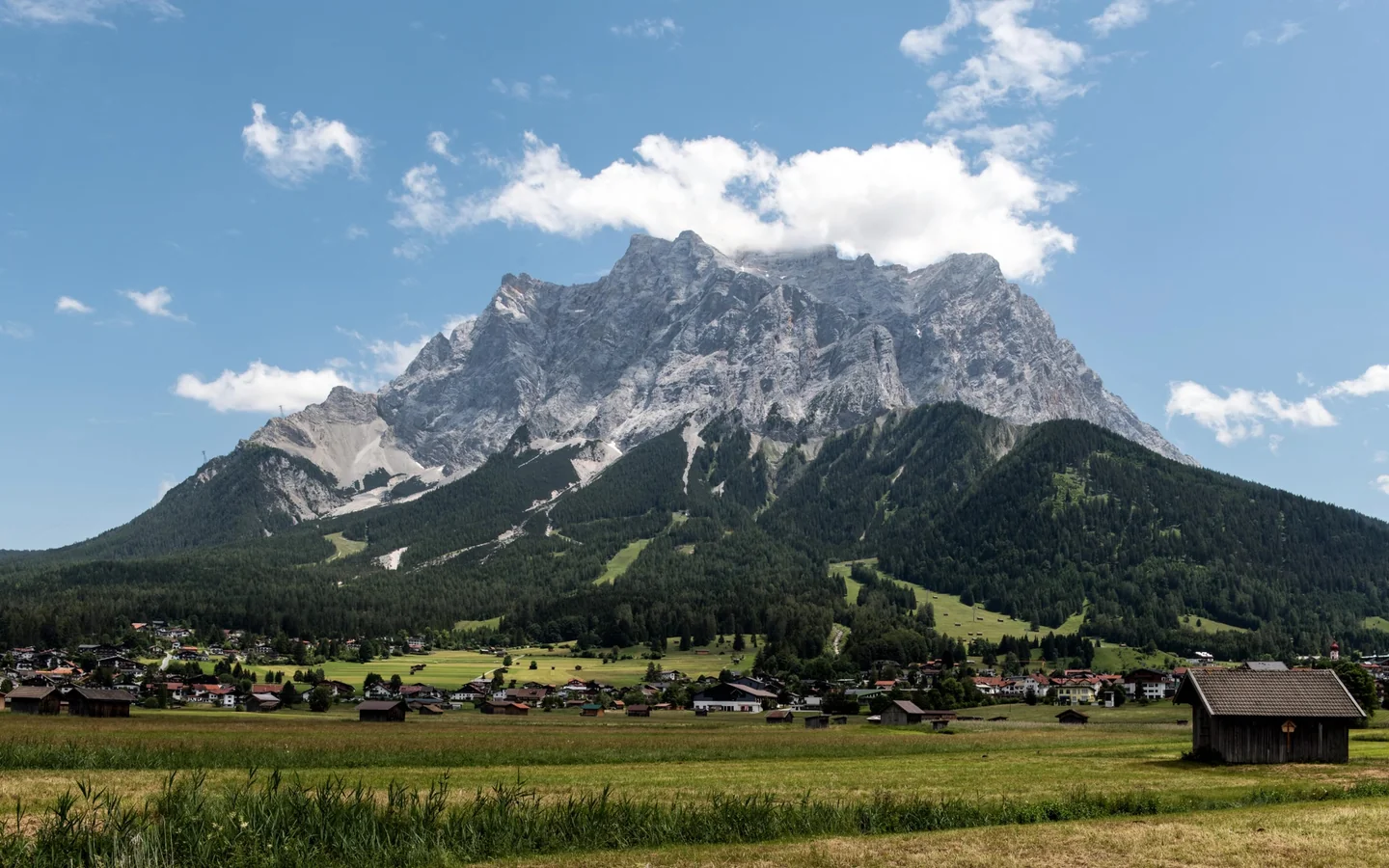 Vista de un alpine mountain village para ilustrar dove andare al fresco in Italia en un entorno de montaña fresca y veraniega.