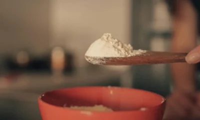Spoon with baking powder for illustrating che cos'è il cremor tartaro in a home baking context