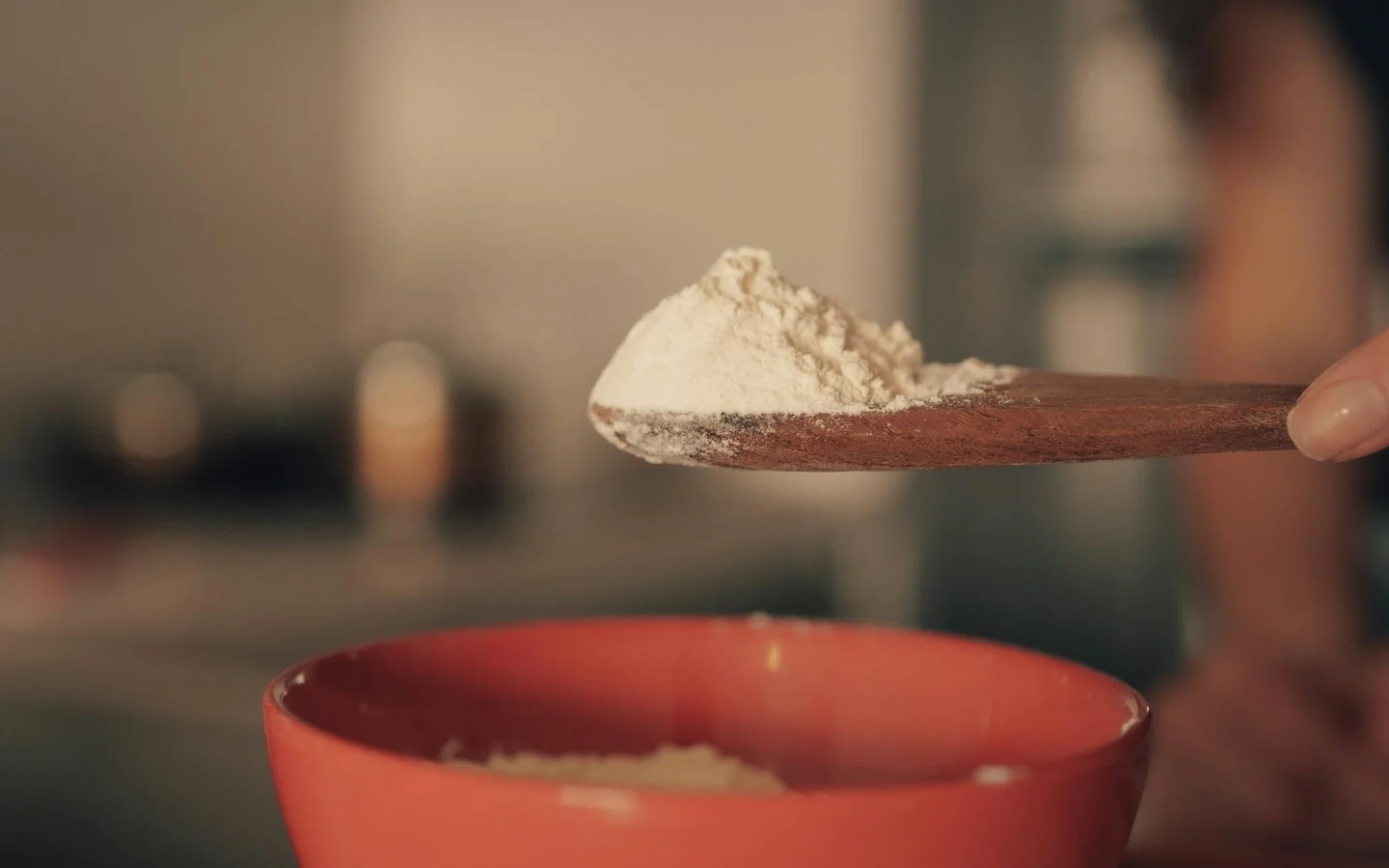 Spoon with baking powder for illustrating che cos'è il cremor tartaro in a home baking context