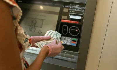 Imagen de un empleado de banco realizando un depósito en ventanilla, útil para ilustrar la consulta "posso versare contanti in una banca diversa dalla mia" en un artículo sobre reglas y controles bancarios.