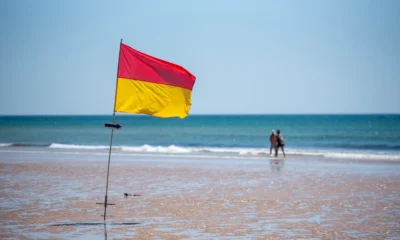 Imagen de una playa con una bandera de seguridad, útil para ilustrar che cosa significano le bandiere in spiaggia.
