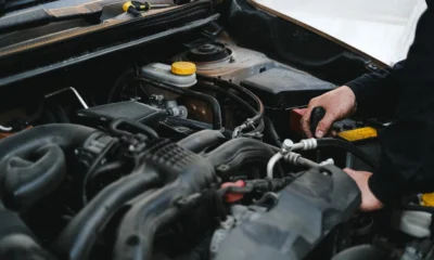 Foto de un mecánico revisando el coche para ilustrar cosa controllare prima di un lungo viaggio in auto antes de salir de viaje