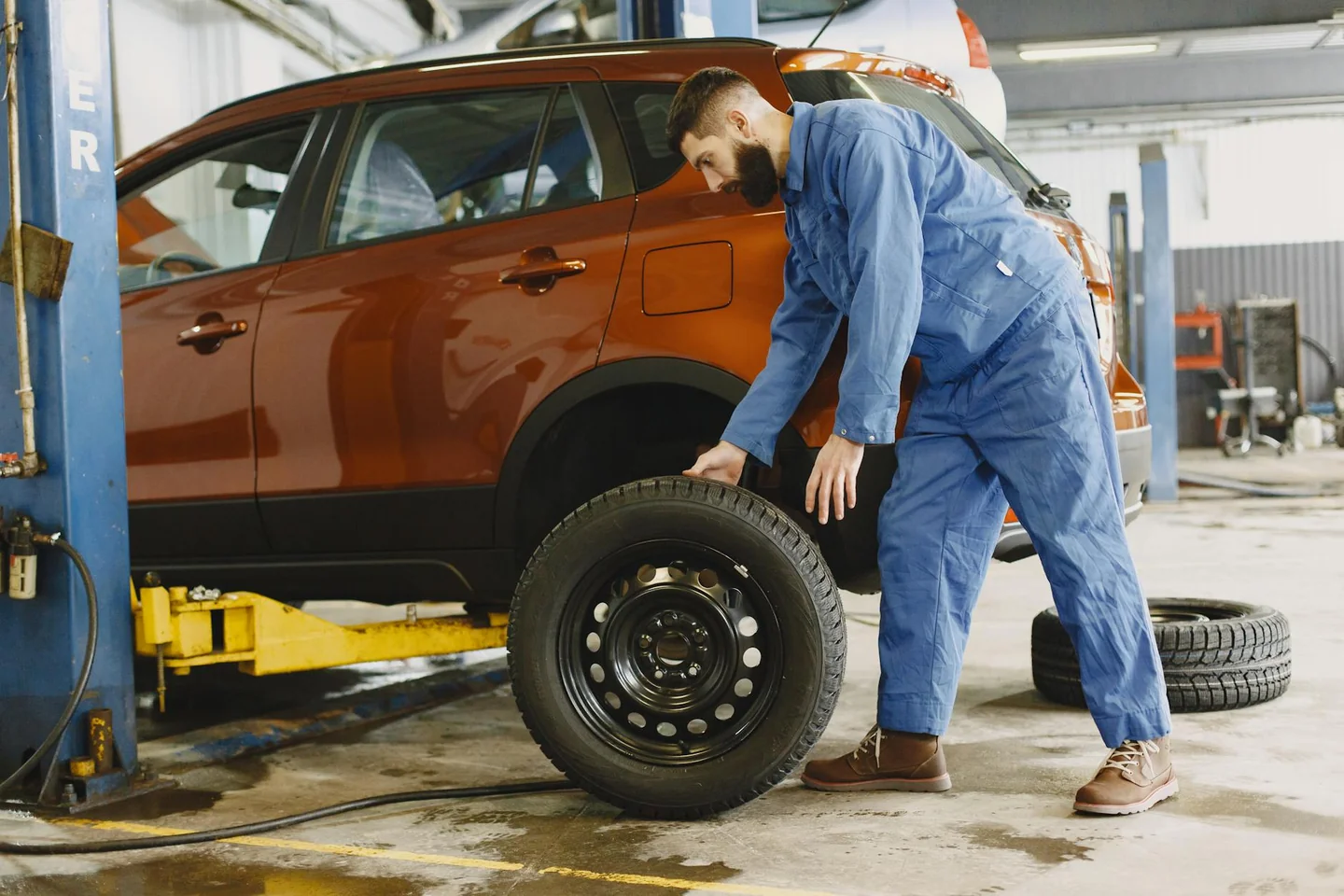 Foto de car tire change para ilustrar "quando si cambiano le gomme estive" en un taller automotriz.