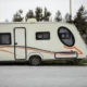 Imagen sobre e possibile alloggiare nei caravan roulottes durante la circolazione, mostrando un caravan remolcado en carretera para ilustrar la circulación y el uso del remolque en marcha.