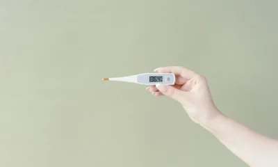 Persona comprobando un termómetro dentro del frigorífico para entender che temperatura deve avere il frigorifero in estate