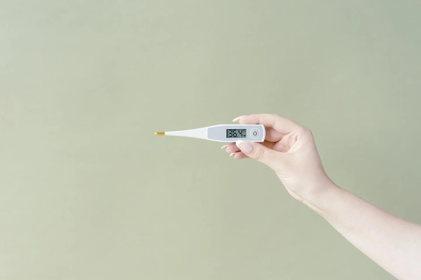Persona comprobando un termómetro dentro del frigorífico para entender che temperatura deve avere il frigorifero in estate