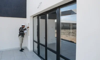 Persona comprobando las ventanas al preparar la salida, relacionado con come lasciare la casa sicura prima delle vacanze.