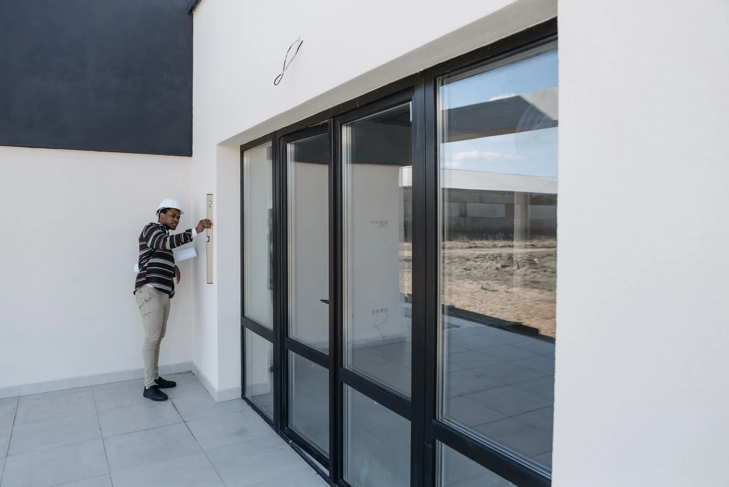Persona comprobando las ventanas al preparar la salida, relacionado con come lasciare la casa sicura prima delle vacanze.