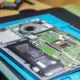 Un técnico en un laboratorio de recuperación de datos trabaja sobre un smartphone dañado relacionado con chi effettua il recupero di dati cancellati su smart smartphone.