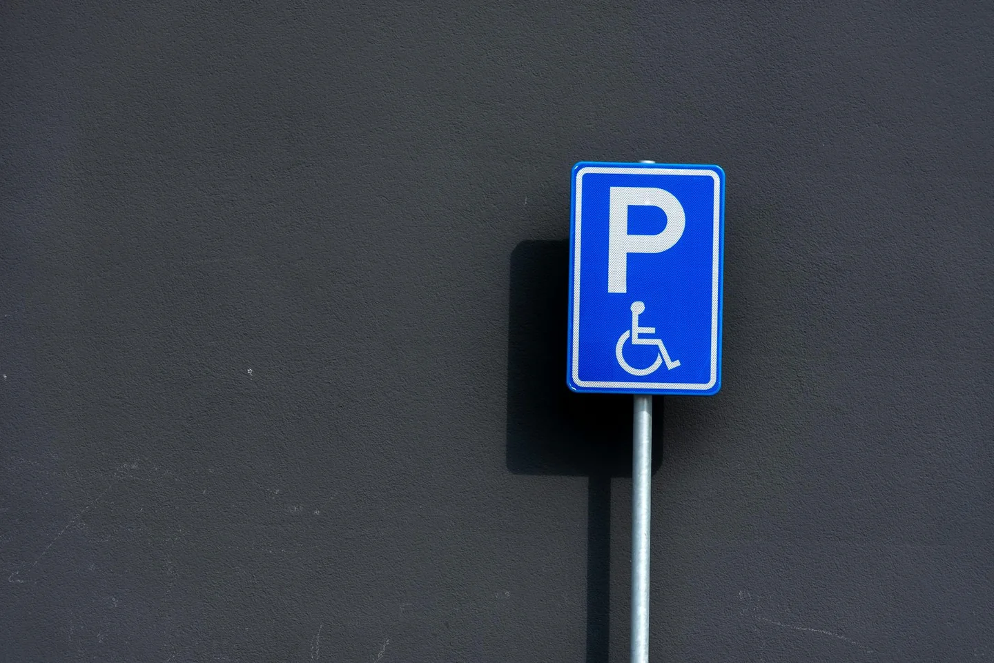 Persona con discapacidad al volante para ilustrar "con la 104 si puo guidare" en un contexto de movilidad y conducción
