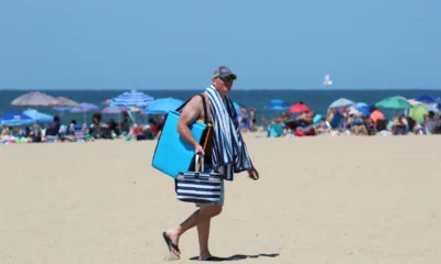Familia preparando una bolsa de playa para "che cosa portare in spiaggia con i bambini" con objetos como crema solar, agua y cambios de ropa.