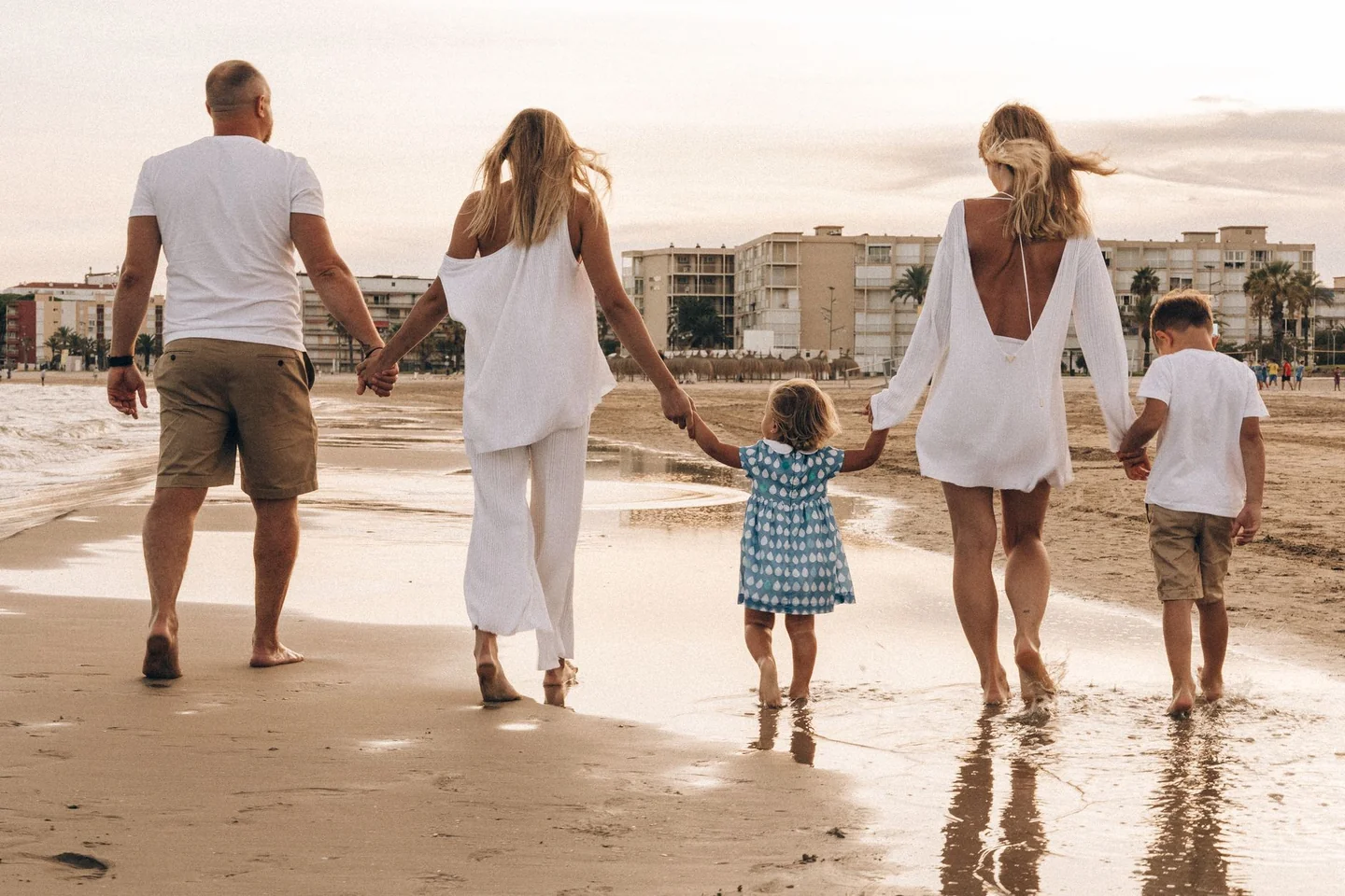 Familia en un resort de playa ilustrando las domande da fare prima di scegliere un villaggio turistico antes de reservar las vacaciones.