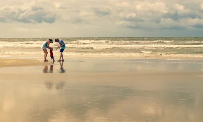 Familia en la playa durante una escena relacionada con quali spiaggia scegliere con i bambini