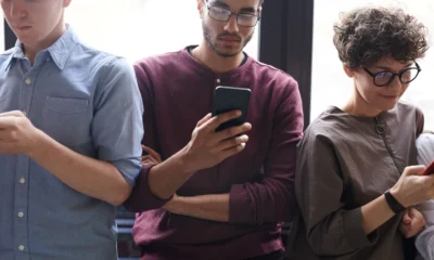 Amigos usando un smartphone para organizar gastos, ideal para el tema "quale app usare per dividere le spese in vacanza" en un viaje en grupo.