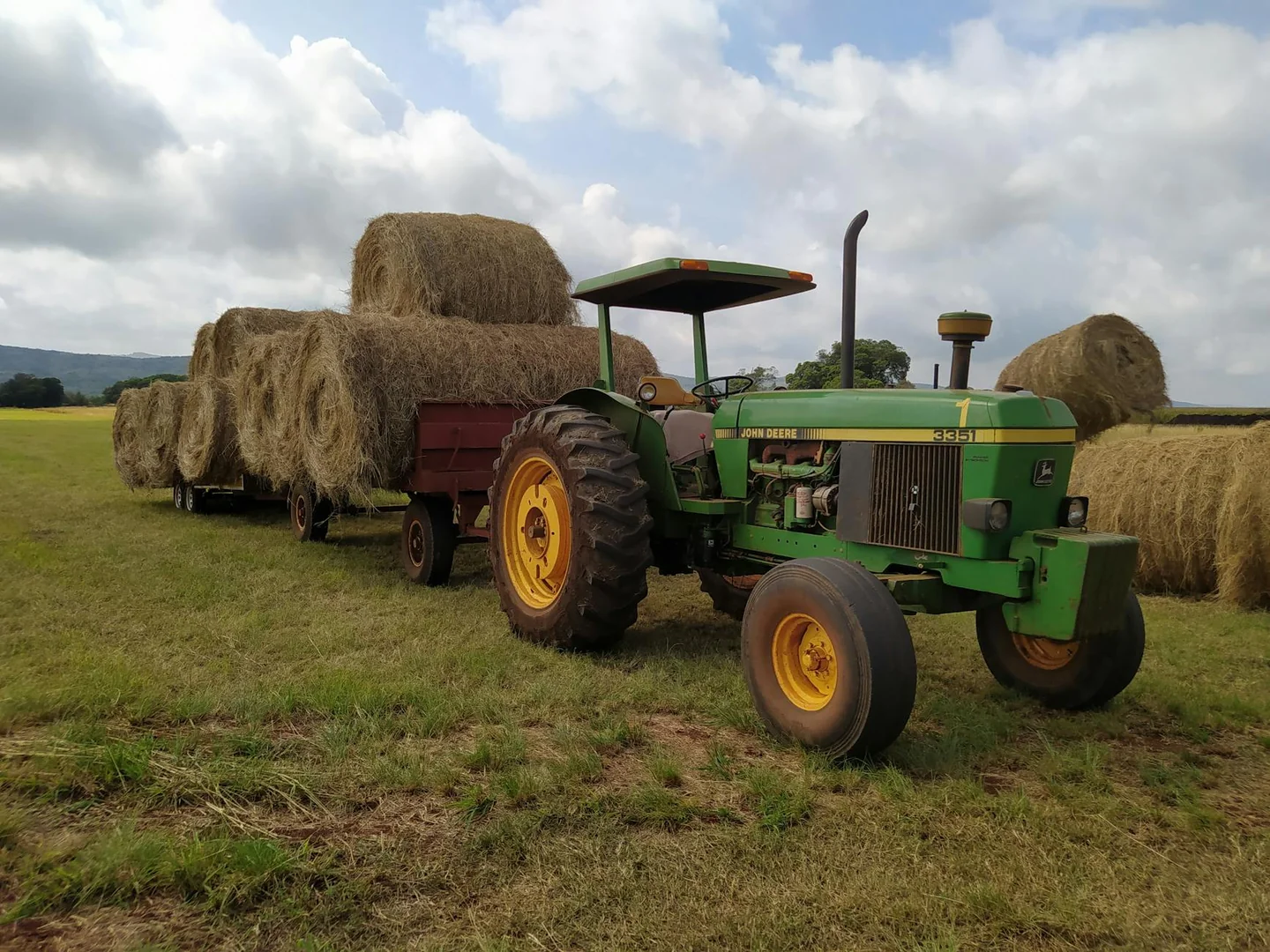 Foto de un tractor moviendo una balota de heno para ilustrar quanto pesa una balla di fieno
