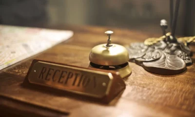 Recepción de hotel relacionada con perché gli hotel chiedono la carta di credito, mostrando el momento en que se pide la tarjeta al huésped.