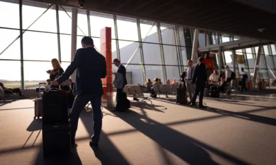 Persona esperando en el aeropuerto por quando il bagaglio viene dichiarato smarrito, junto al carrusel de equipaje