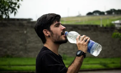 Imagen de un hombre bebiendo agua para ilustrar quanto bere quando fa caldo en una situación de calor y deshidratación.